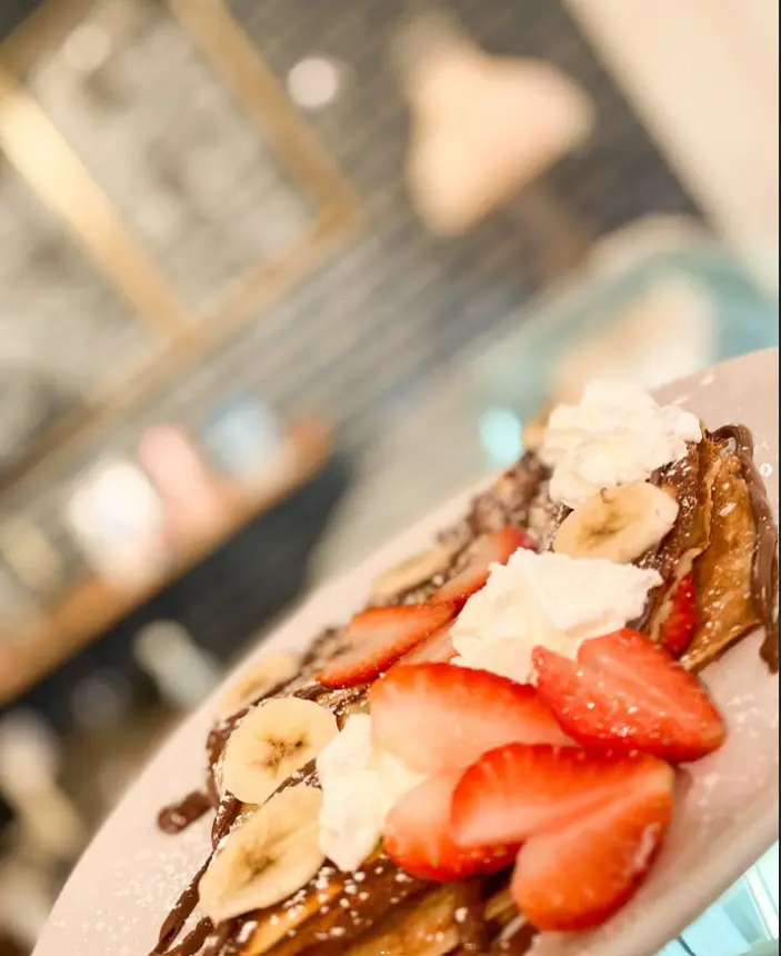 A sweet crêpe with strawberries, banana, Nutella drizzle and whipped cream at Creperie Antoinette